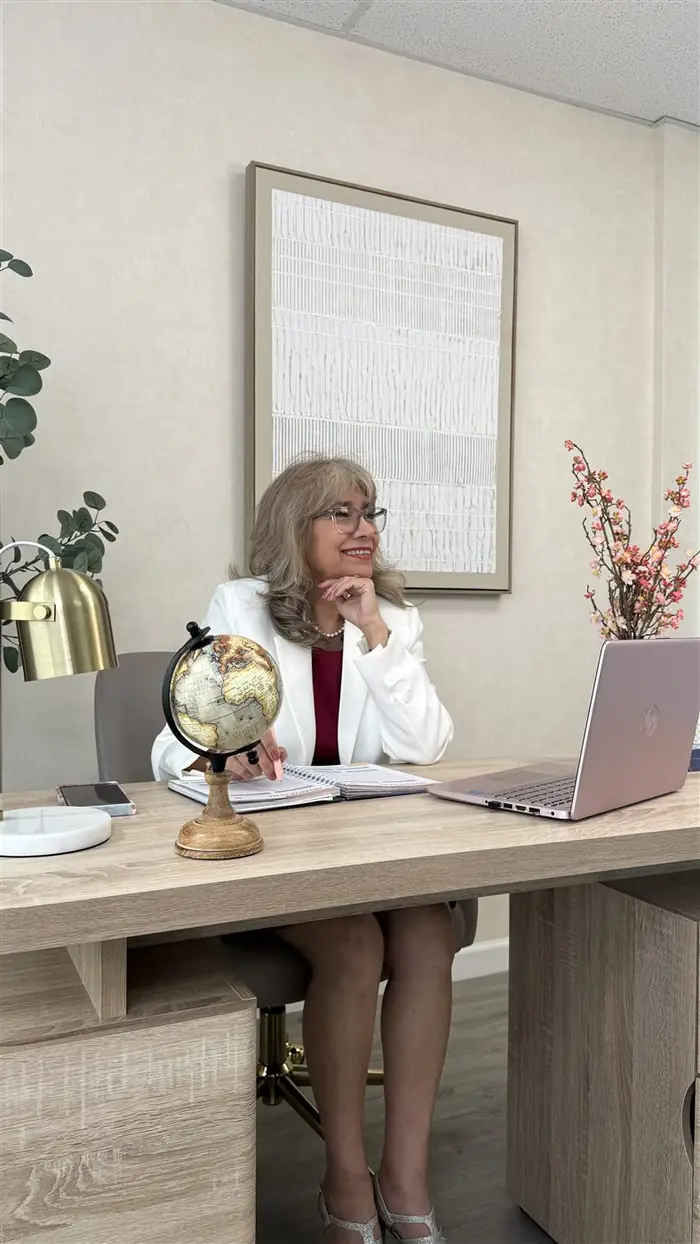 Luz Barón of Luzmak Insurance at her office desk with a laptop — brand photography session in Orlando